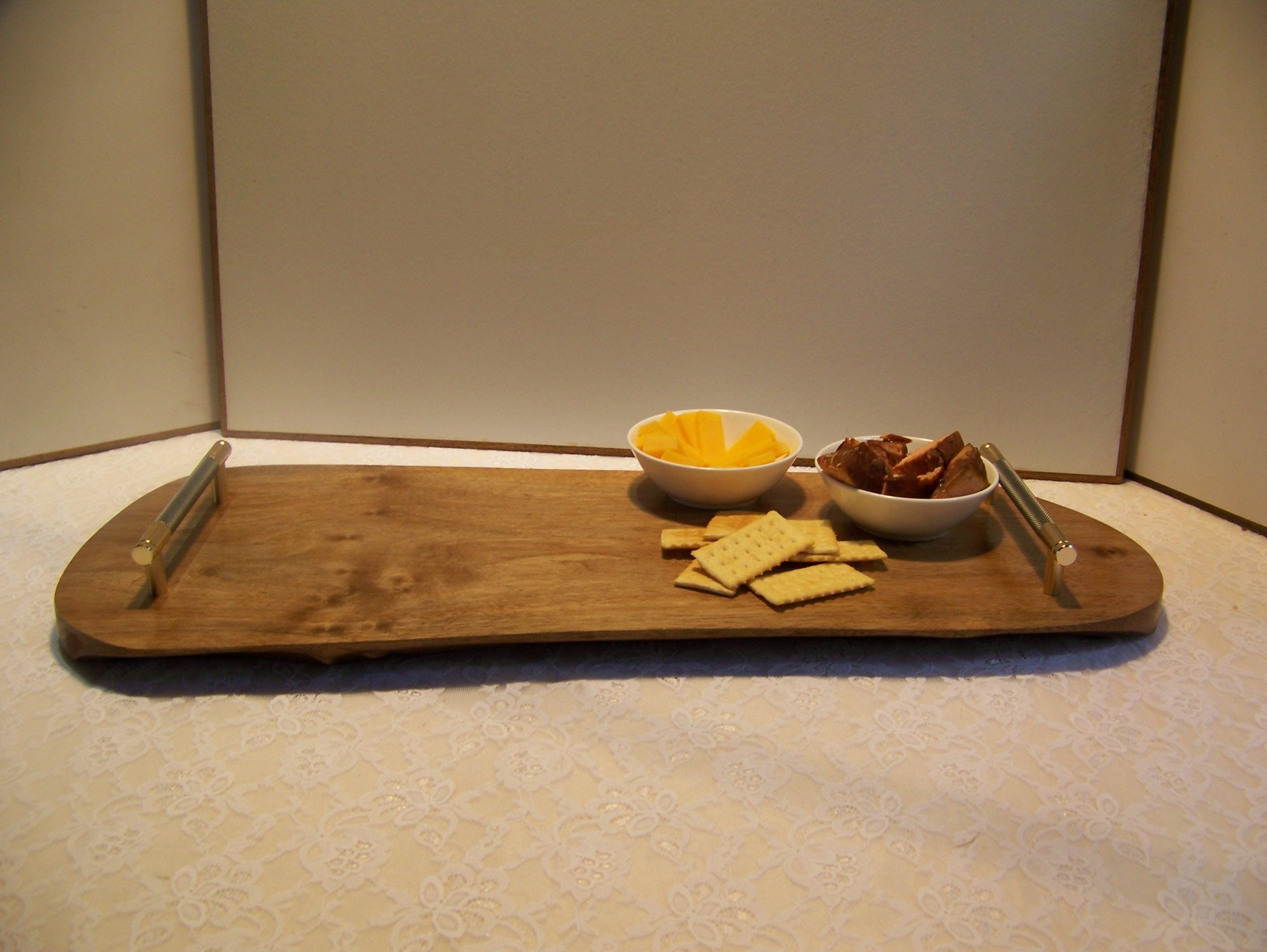 Live Edge Walnut Charcuterie Board with Brass/gray knurled handles.